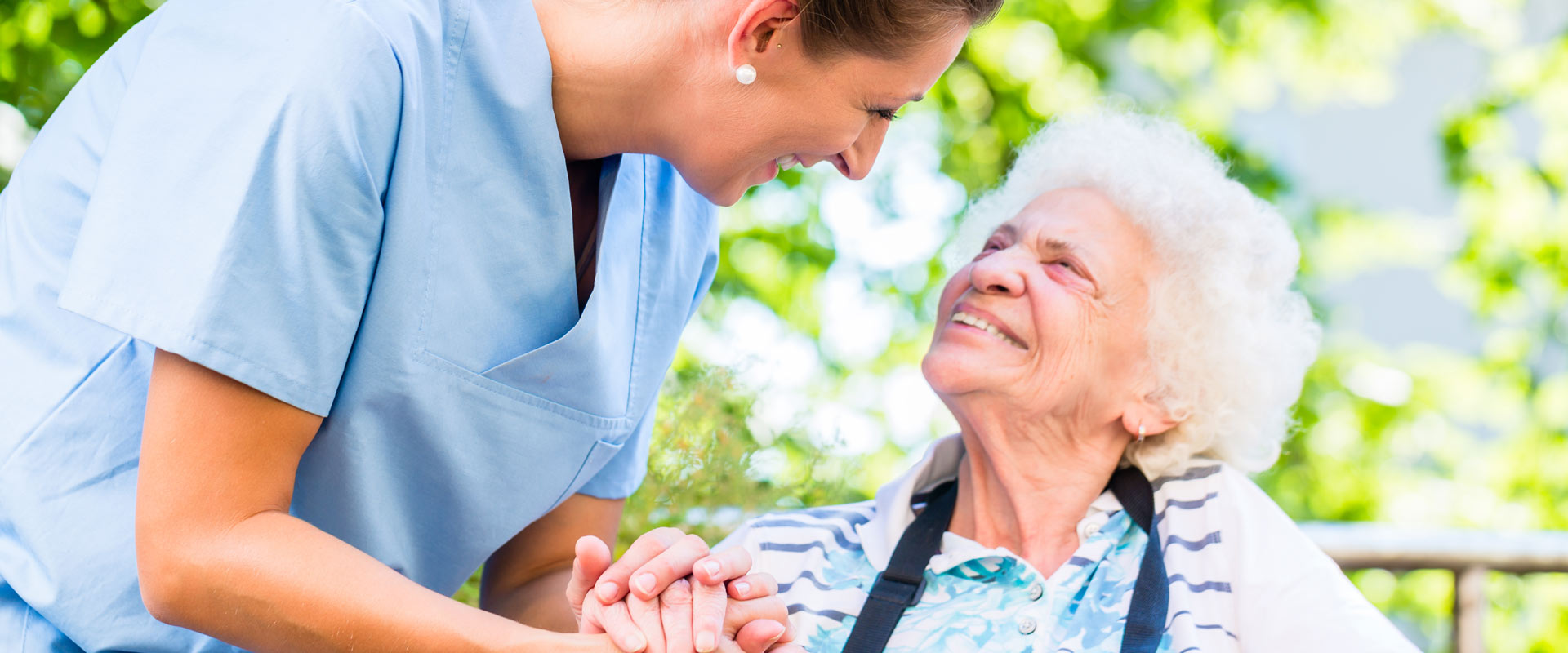 Nurse holding hand of senior woman in pension home