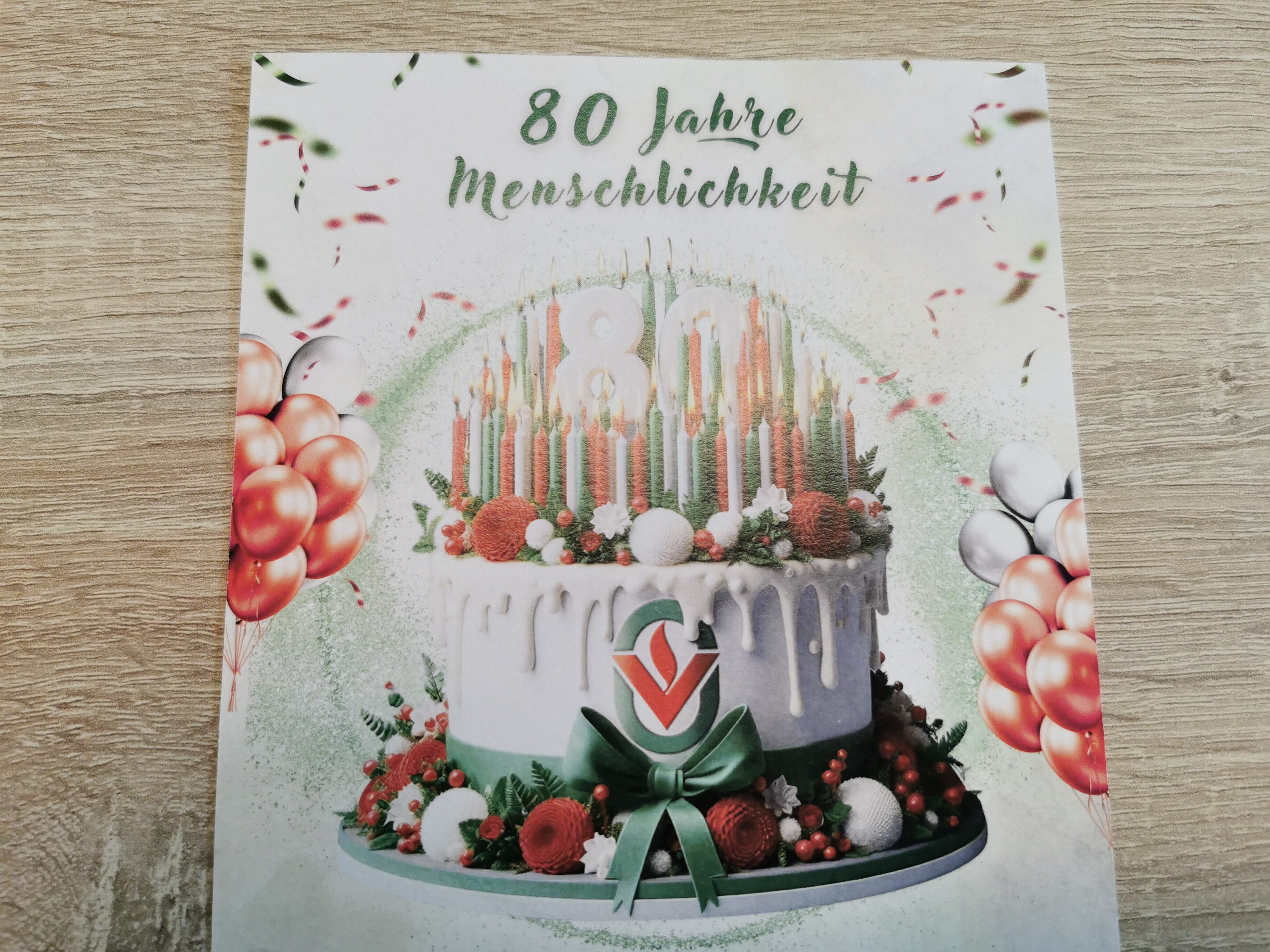 Ein dekorativer Geburtstagskuchen mit Kerzen und Ballons.